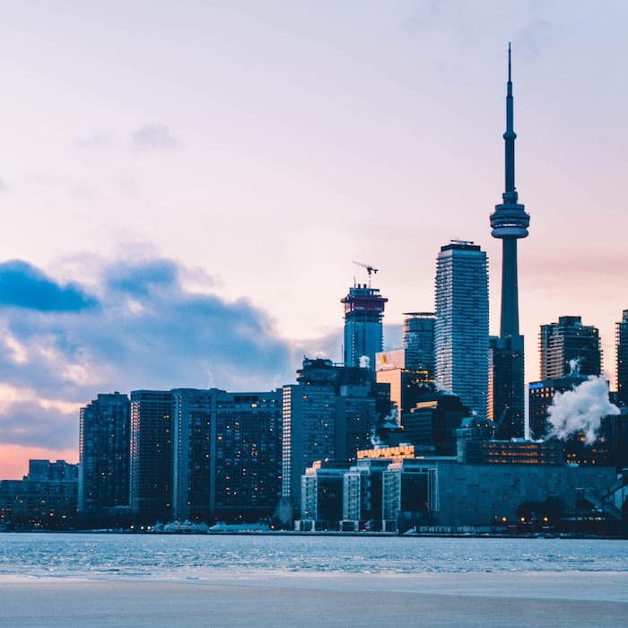 Toronto skyline from island beach at dusk.