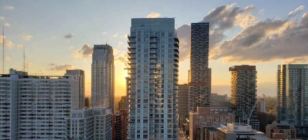 Toronto Condos in skyline with sun setting behind the buildings