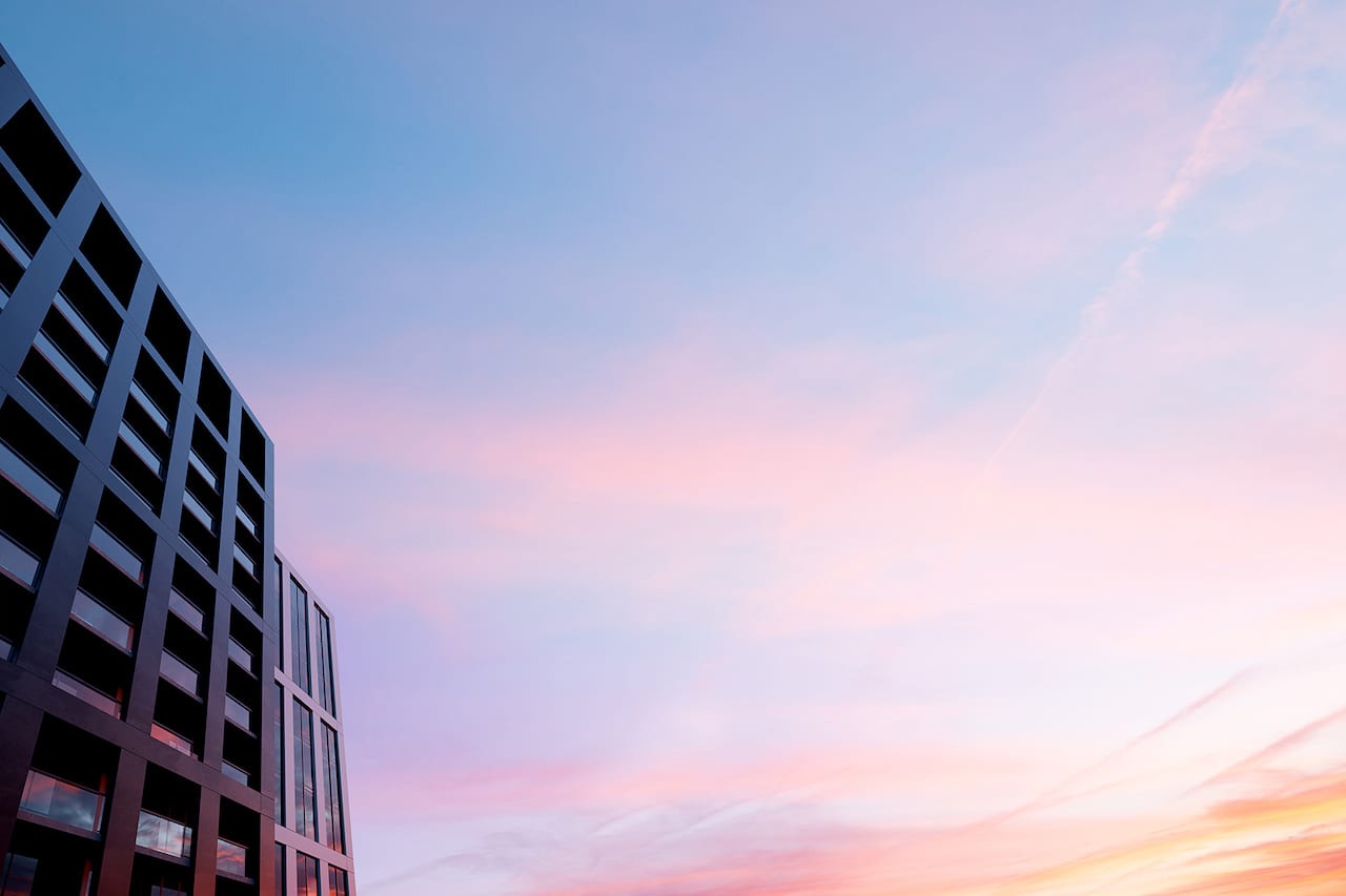 Exterior rendering of M5 Condos and a pastel sunset