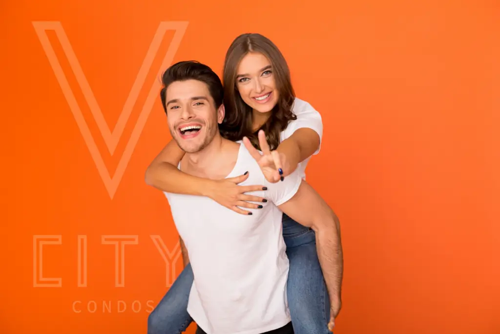 Two models posing happily for V City Condos