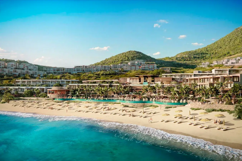 Aerial view of Vie L'Ven luxury beachfront resort with palm trees and loungers on the sandy shores of St. Maarten.