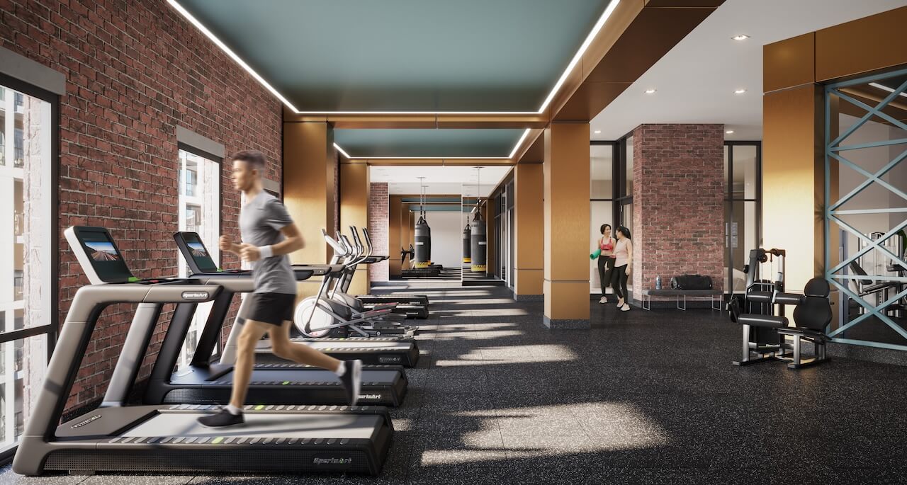 Interior of a modern fitness studio with treadmills, exercise bikes, and punching bags, featuring exposed brick and contemporary design.